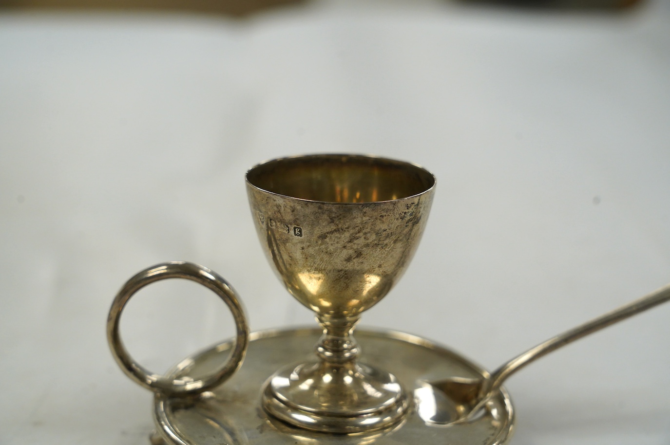 An Edwardian silver egg cup on stand, Birmingham, 1904, 67mm, together with a George III associated spoon. Condition - fair